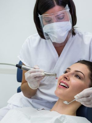 dentist-examining-female-patient-with-tools-scaled.jpg